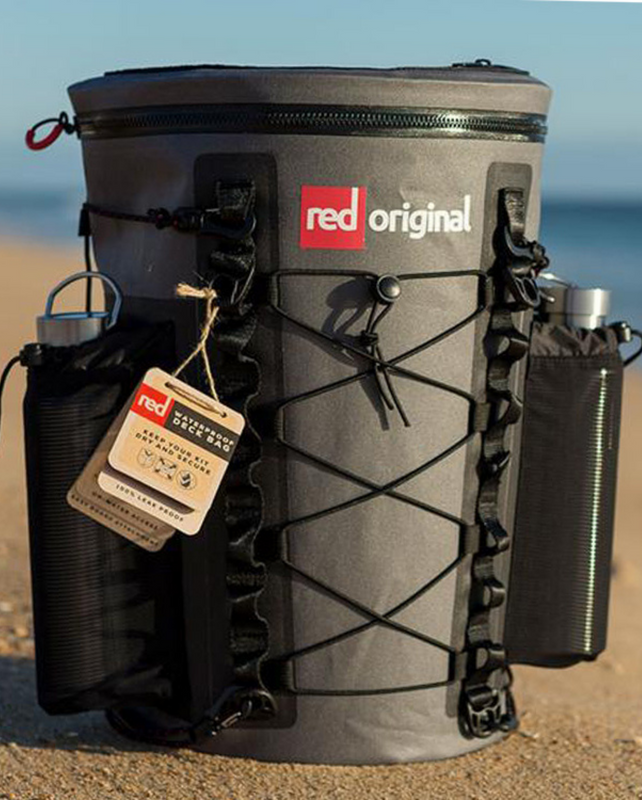 Red Paddle Co Waterproof SUP Deck Bag with 2 Insulated water bottles in external pockets on a beach