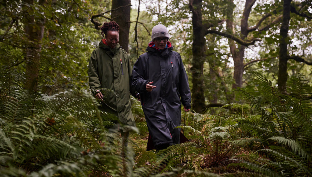 2 people walking through the forest wearing their Red Pro Change Robe