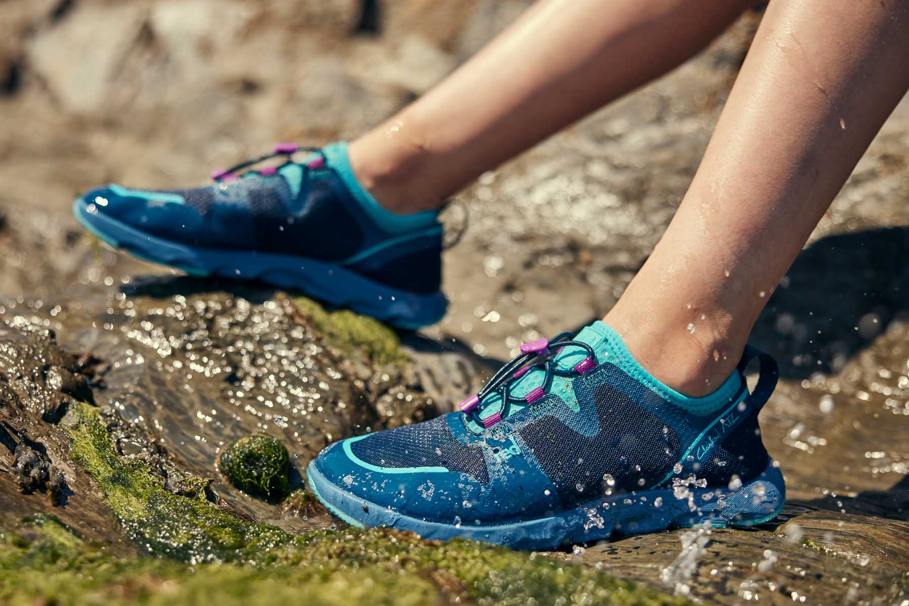 Blue aqua shoes against beach rocks