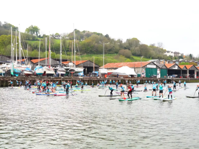 A group of people paddleboarding in a racing event
