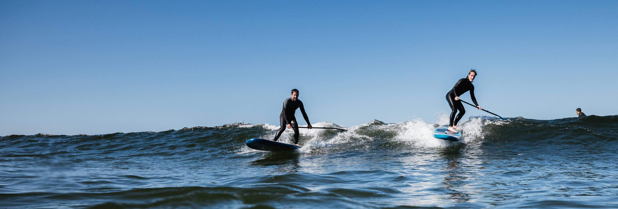 paddleboarders riding future series boards on wave