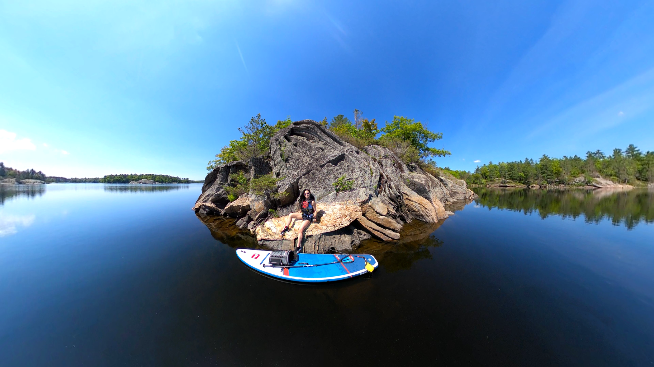 Woman sat on a rock in a lake with Red Original