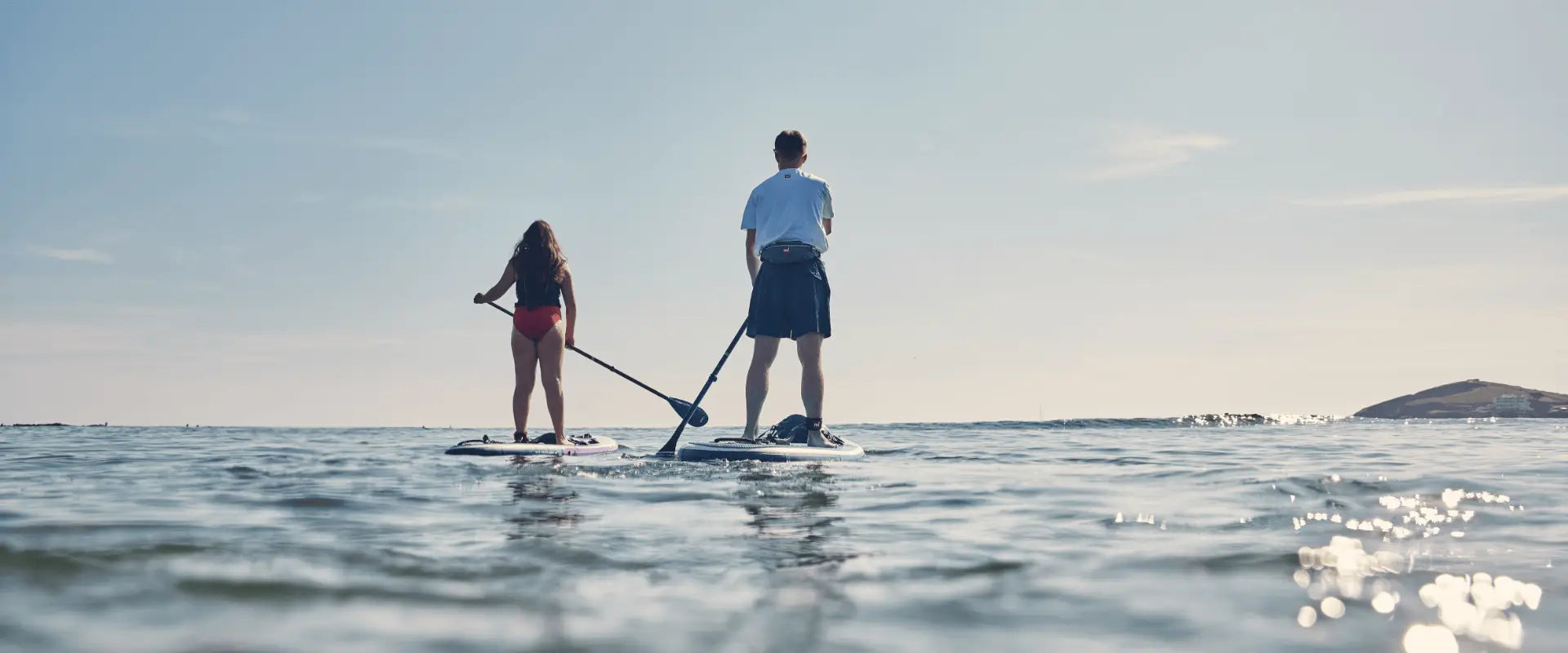 two people paddling towards horizon