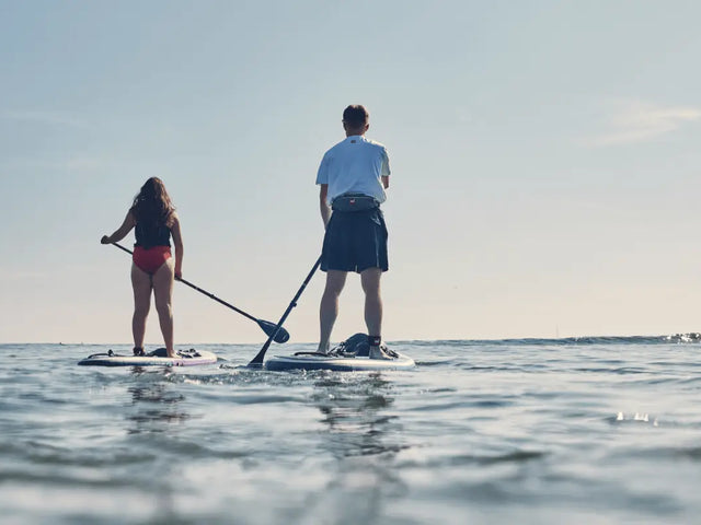 two people paddling towards horizon
