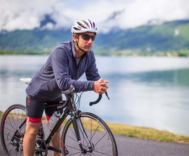 Man sat on bicycle wearing Red Original long sleeved performance top