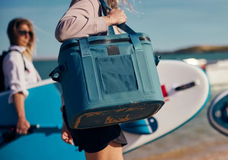 woman carrying waterproof cooler bag on the beach