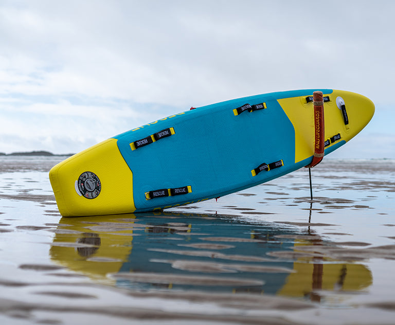 Red Rescue paddle board on water surface 