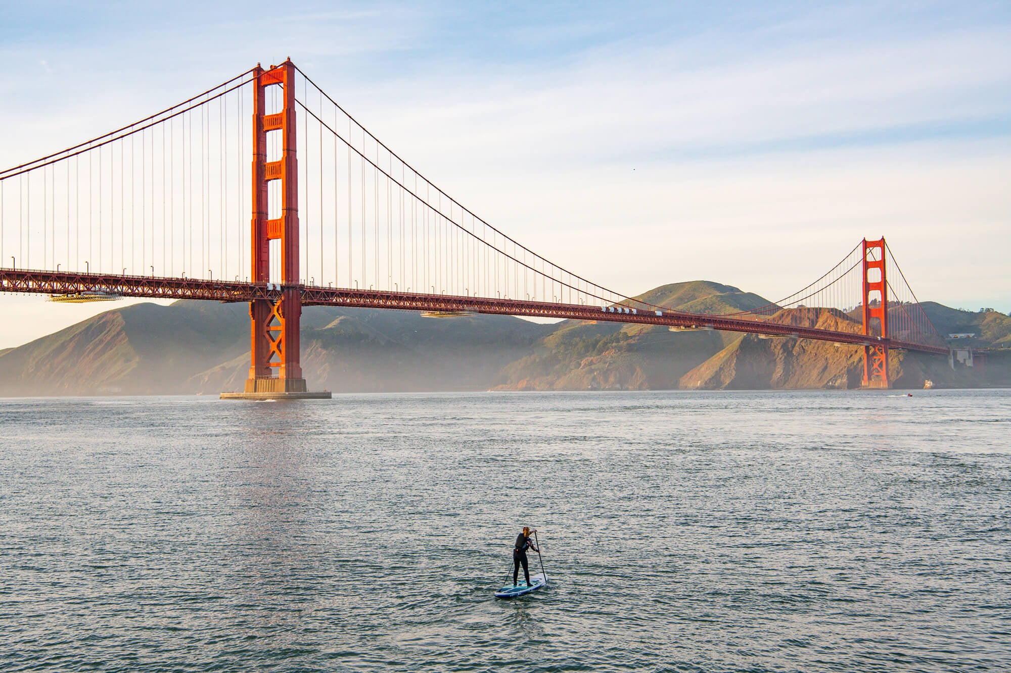 Woman Paddle Boarding Toward The Golden Gate Bridge