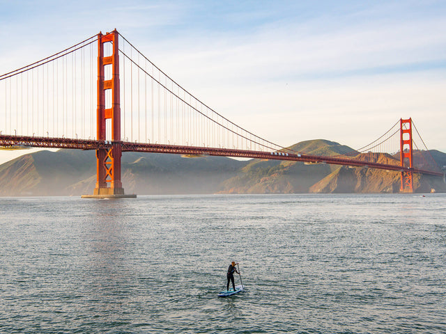 Woman Paddle Boarding Toward The Golden Gate Bridge