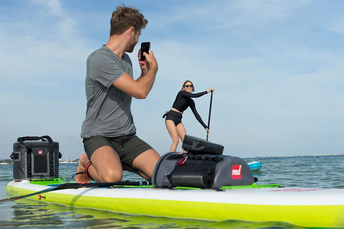 man and woman paddleboarding with deck bag