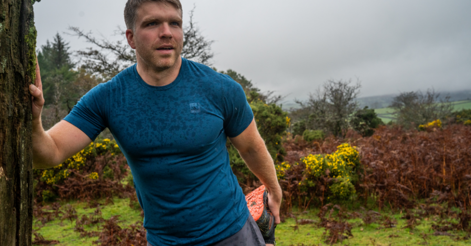 Man stretching wearing Red Original performance T-shirt in navy