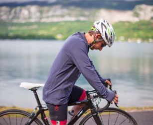 Man sat on bicycle wearing Red Original performance long sleeve top