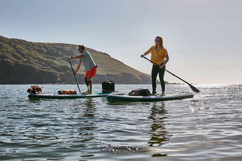 Man and woman paddle boarding on lake