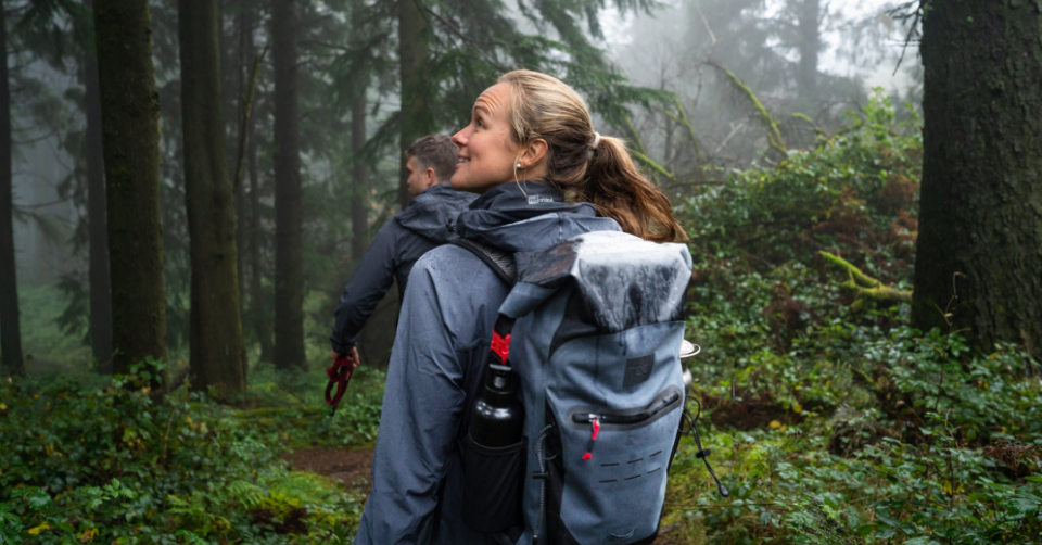 Man and woman hiking in forrest wearing Red Original active jackets