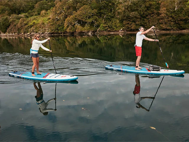 man and woman on a lake paddling touring SUP boards