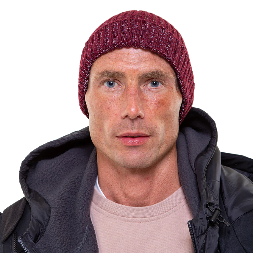 A man wearing a burgundy beanie looking at the camera